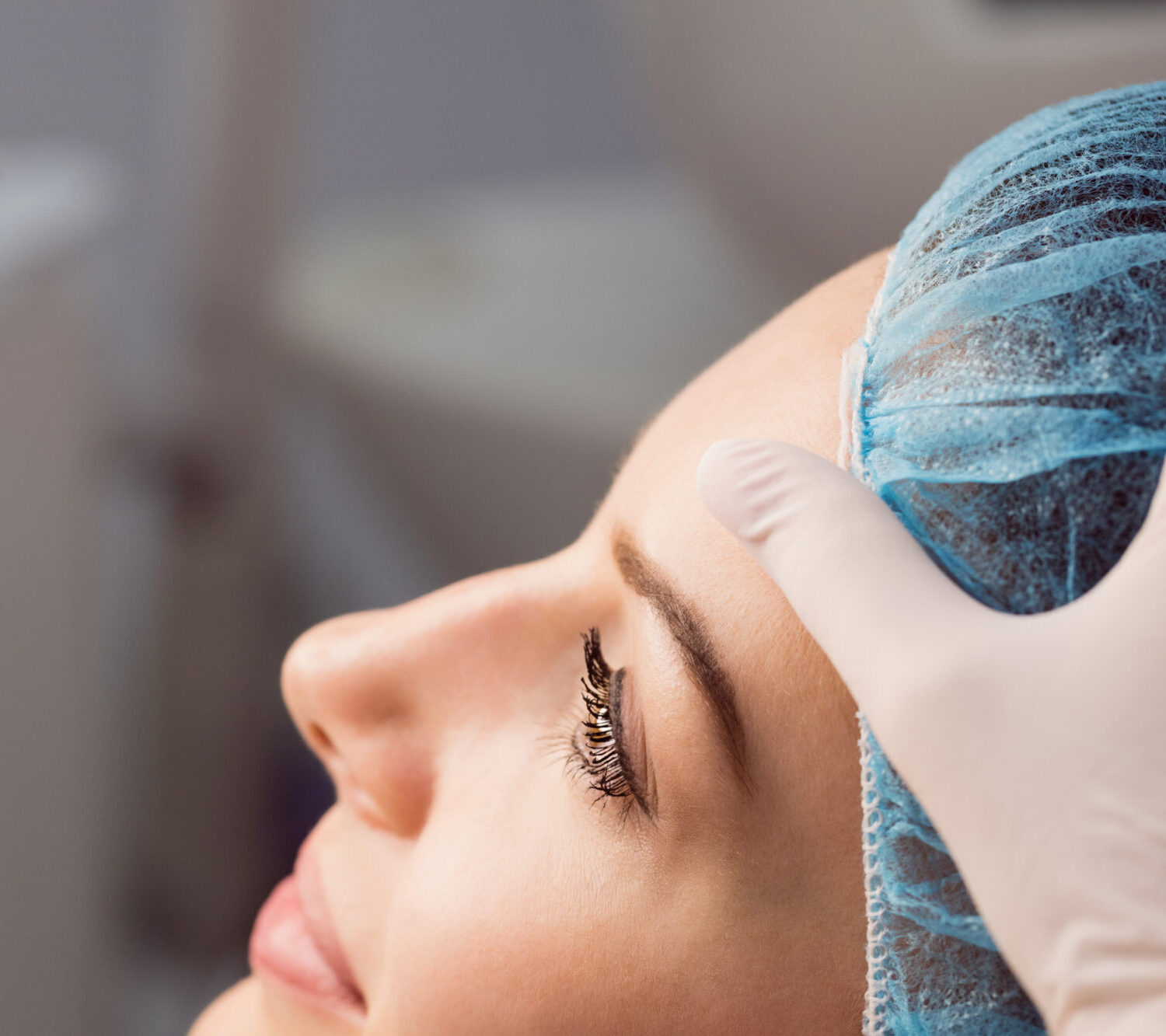Hands of doctor examining womans face for cosmetic treatment at clinic